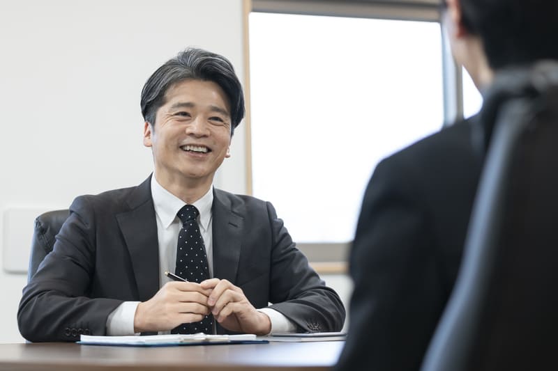 スーツを着た男性が話をしている写真