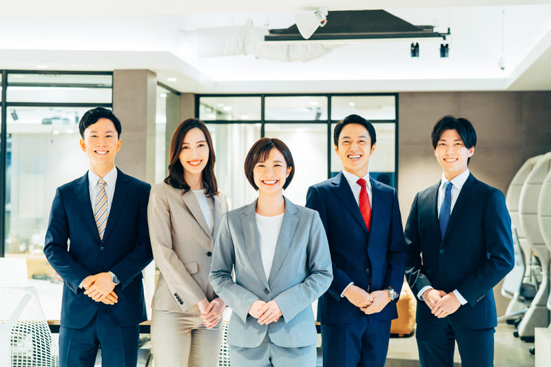 オフィスの中で並ぶ男女の写真