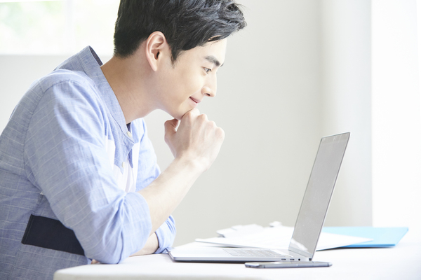 ノートパソコンを使用している男性の写真